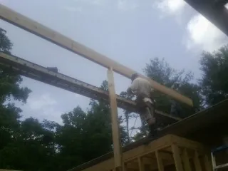 Carpenter setting a ridge beam over a new addition frame — Ice Dam Removal by Roofing Brothers in Nazareth