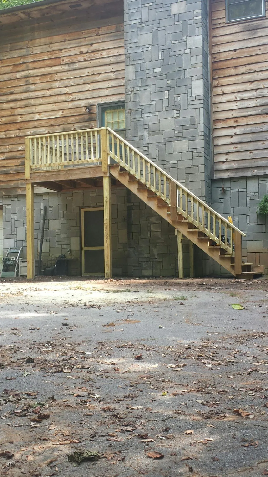 New pressure treated deck and stair landing on a log home in Nazareth