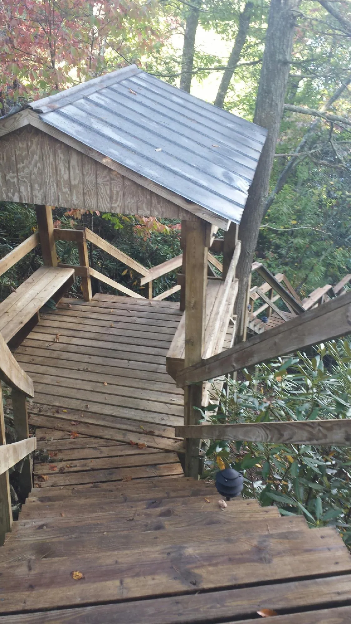 Metal roofed shelter over wooden steps on a wooded walkway — Skylight Repair & Installation work by our crew in Nazareth